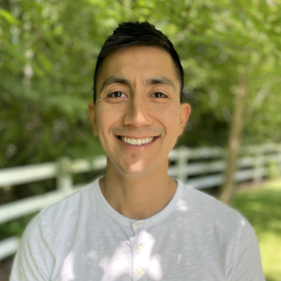 Geovanny Vazquez headshot. He is wearing a white shirt in front of an outdoor background
